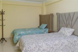 ワラスにあるAmplio departamento 3 dorm-Centro Huarazのベッドと椅子のある寝室