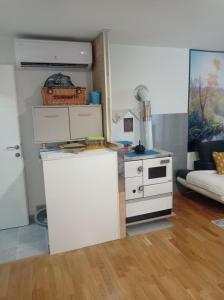 a living room with a white kitchen with a stove at Little Joy Lodge , Loč Mala Radost in Bihać
