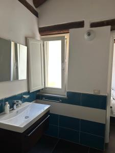 a bathroom with a white sink and a window at Affitti brevi FESAGI in Laurino +25 photos