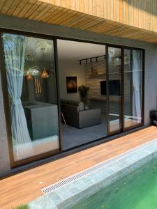 eine Glaserweiterung eines Hauses mit Pool in der Unterkunft Ap Piscina Privativa Próximo da capela dos Milagres in São Miguel dos Milagres