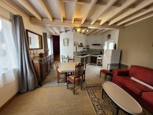 a living room with a red couch and a table at Gîte le cyprès in Tigy