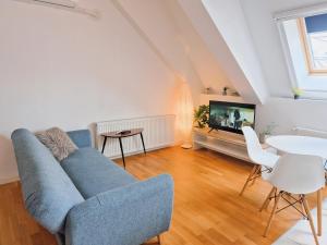 a living room with a blue couch and a tv at Bucharest Central DD Apartment in Bucharest