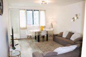 a living room with a couch and a table at Les Erables Appart - 3 chambres - Spacieux et moderne avec balcon, parking et wifi in Saint-Jean-de-la-Ruelle