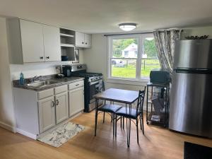a kitchen with a table and a sink and a refrigerator at Woodford Rest in Woodford