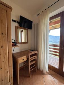 a desk in a room with a window and a table at Agritur Le Pergole in Villa Lagarina