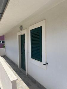 a door with a green window on the side of a building at Apartman 4 Majba in Zaglavice +9 photos