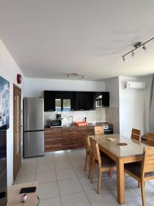 a kitchen and dining room with a table and refrigerator at Apartman 4 Majba in Zaglavice