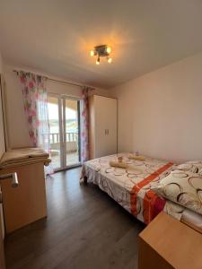 a bedroom with a bed and a sliding glass door at Apartman 4 Majba in Zaglavice