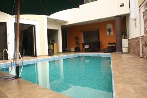 uma piscina com um guarda-sol ao lado de uma casa em Casa Corazon de Plata Suites em Guanajuato