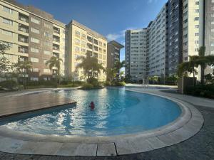 a person in a swimming pool with buildings at A place to stay in Iloilo City