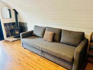 a couch in a living room with a stove at Welcome to La Petite Ferme & Family in Carracastle