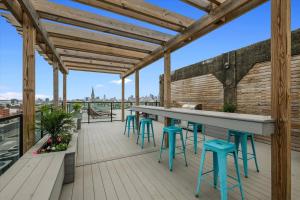 a roof deck with a bar and stools at XL Studio - Studio with Pool & Scenic Rooftop in Philadelphia