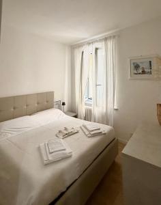 een witte slaapkamer met een bed met handdoeken erop bij Diletta Luxury Apartment in Senigallia