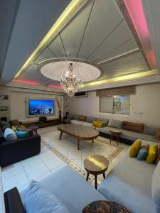 a large living room with couches and a chandelier at Villa Royale Prestige Safaa in Dar Bouazza