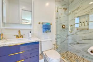 a bathroom with a toilet and a glass shower at Monarch Estate, Luxe Studio with AC , Walk to Beach, Pier & Dining in Oceanside