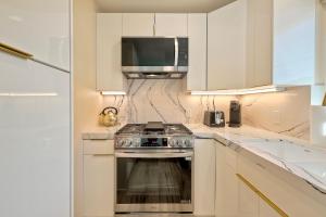 a kitchen with a stove and a microwave at Monarch Estate, Luxe Studio with AC , Walk to Beach, Pier & Dining in Oceanside