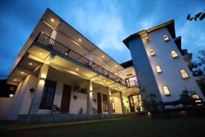 a large white building with lights on it at Kudila Resort in Anuradhapura