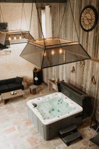 a jacuzzi tub in a living room with a clock at le petit château de Célestine in Segonzac