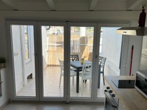 een keuken met glazen schuifdeuren met een tafel op een balkon bij Maison Remì in Castellana Grotte +4 foto's