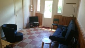 - un salon avec un canapé, des chaises et une télévision dans l'établissement Villa Marguerite, à Ax-les-Thermes