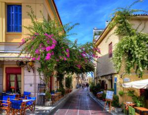 a street in a town with tables and chairs and flowers at Dreamin Athens - Monastiraki Apartments in Athens