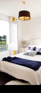 ein Schlafzimmer mit einem großen weißen Bett mit blauen Kissen in der Unterkunft Casa Romero Garden in Vilanova de Arousa