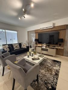 a living room with a couch and a tv at Atalanta rooms in Larnaca