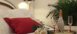 ein Bett mit einem roten Kissen und ein Tisch mit Weingläsern in der Unterkunft Casa Romero Garden in Vilanova de Arousa + 17 Fotos