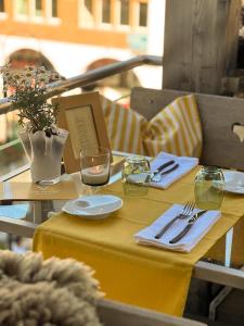 a table with a yellow table cloth and glasses on it at Backstage Boutique SPA Hotel in Zermatt