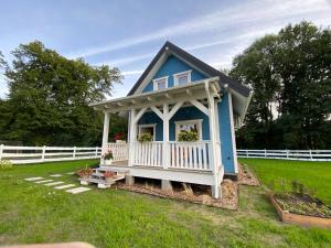 a small blue house with a porch in a yard at Osada California in Grudna