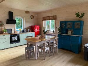 a kitchen with blue cabinets and a table and chairs at Osada California in Grudna