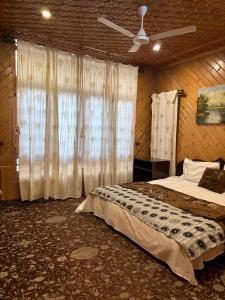 een slaapkamer met een bed en een plafondventilator bij Grand Stone&Wood 3 Room Mansion in Srinagar