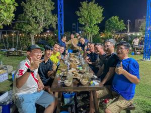a group of people sitting around a long table at Mekong Camping Deluxe in Ấp Thanh Sơn (1)