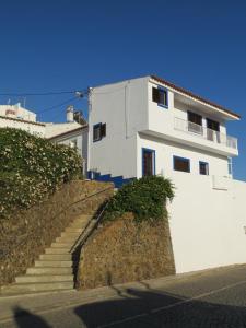 ein weißes Gebäude mit einer Treppe davor in der Unterkunft Casa Barroca in Carrapateira