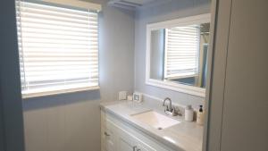 a bathroom with a sink and two windows at Blue Horizon Lake House - Renovated 3BR 2BA on the Beach in Bay City +8 photos