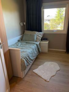 a small bed in a room with a window at Modern 3 bedroom villa 10min from Oslo Airport Gardermoen in Jessheim