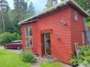 a red house with a red door in a yard at Nature- & lakeside accommodation in Lerum