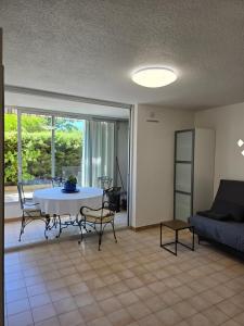 a living room with a table and chairs and a couch at 2 pièces en rez- de -jardin in Saint-Raphaël +11 photos