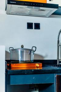 a pot on top of a stove in a kitchen at Banora Apartments Gwarinpa in Gwarinpa +3 photos