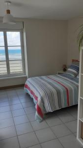 a bedroom with a bed with a view of the ocean at Le Studio du Nevet in Douarnenez
