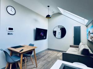 特鲁罗Uno in the City - Luxury Serviced Accommodation的带沙发、桌子和时钟的客厅