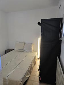 a bed in a small room with a black curtain at 2 pièces en rez- de -jardin in Saint-Raphaël