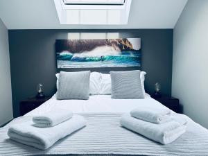 特鲁罗Uno in the City - Luxury Serviced Accommodation的一间卧室，有一张大床，床上有两条毛巾