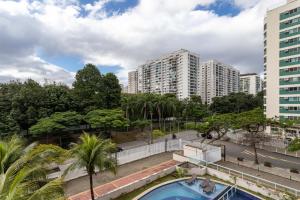 Blick auf einen Pool mit Gebäuden im Hintergrund in der Unterkunft Verano Stay Barra Olímpica in Rio de Janeiro