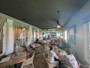 two women sitting at tables in a restaurant at Carambola Rooms in Las Delicias
