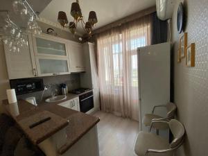 a kitchen with a sink and a refrigerator at Студия in Bishkek