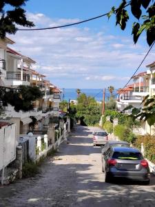 two cars parked on a street with houses at Spacious apartment Nantia's apartment in Hanioti