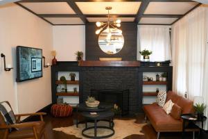 un soggiorno con camino in mattoni e lampadario pendente di Cozy Atl Getaway - 5 Min From Airport & Downtown ad Atlanta
