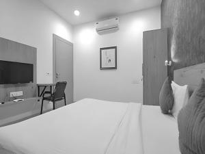 una camera da letto con un letto, una scrivania e una televisione di Stay Retreat At Hotel Destiny Near Railway Station Indore a Indore