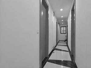 un corridoio con pareti bianche e pavimenti bianchi e neri di Stay Retreat At Hotel Destiny Near Railway Station Indore a Indore